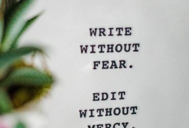 white plaque with words printed in black and plant unfocused in foreground